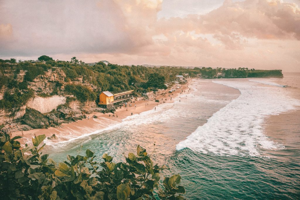 A beautiful beach on Balangan Beach in Uluwatu, Bali with people swimming